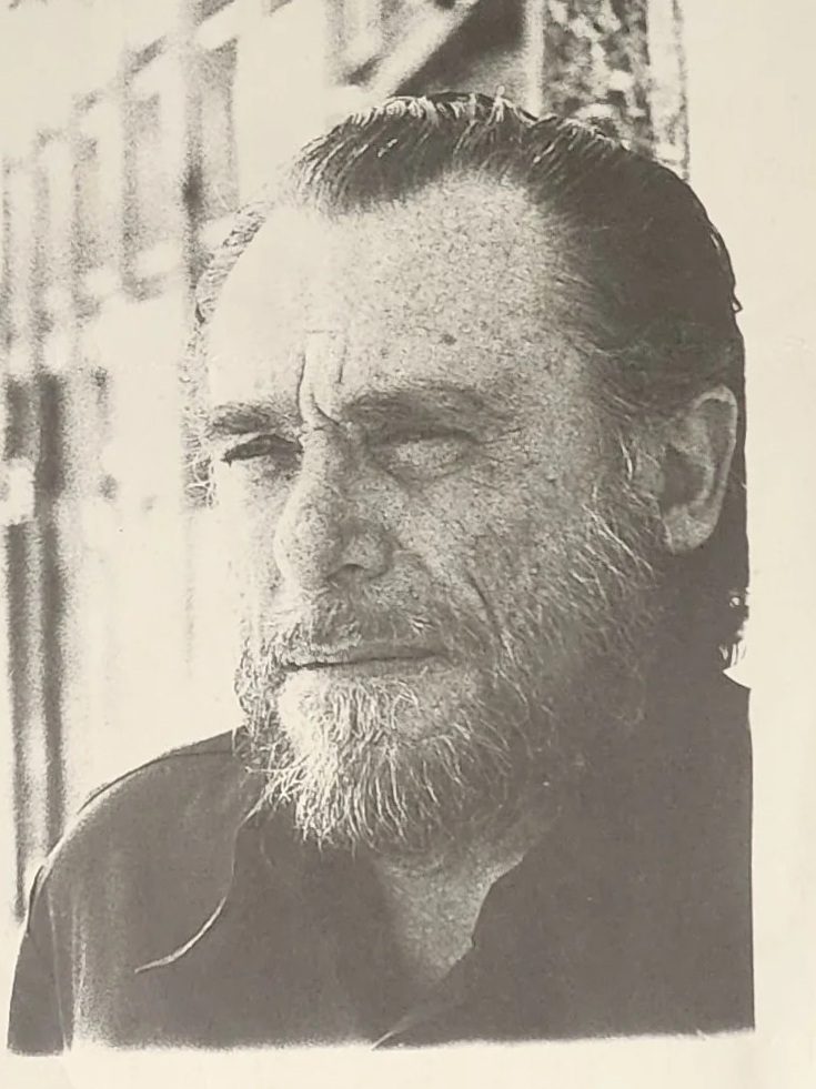 Black and white portrait of Charles Bukowski with a beard, looking to the side
